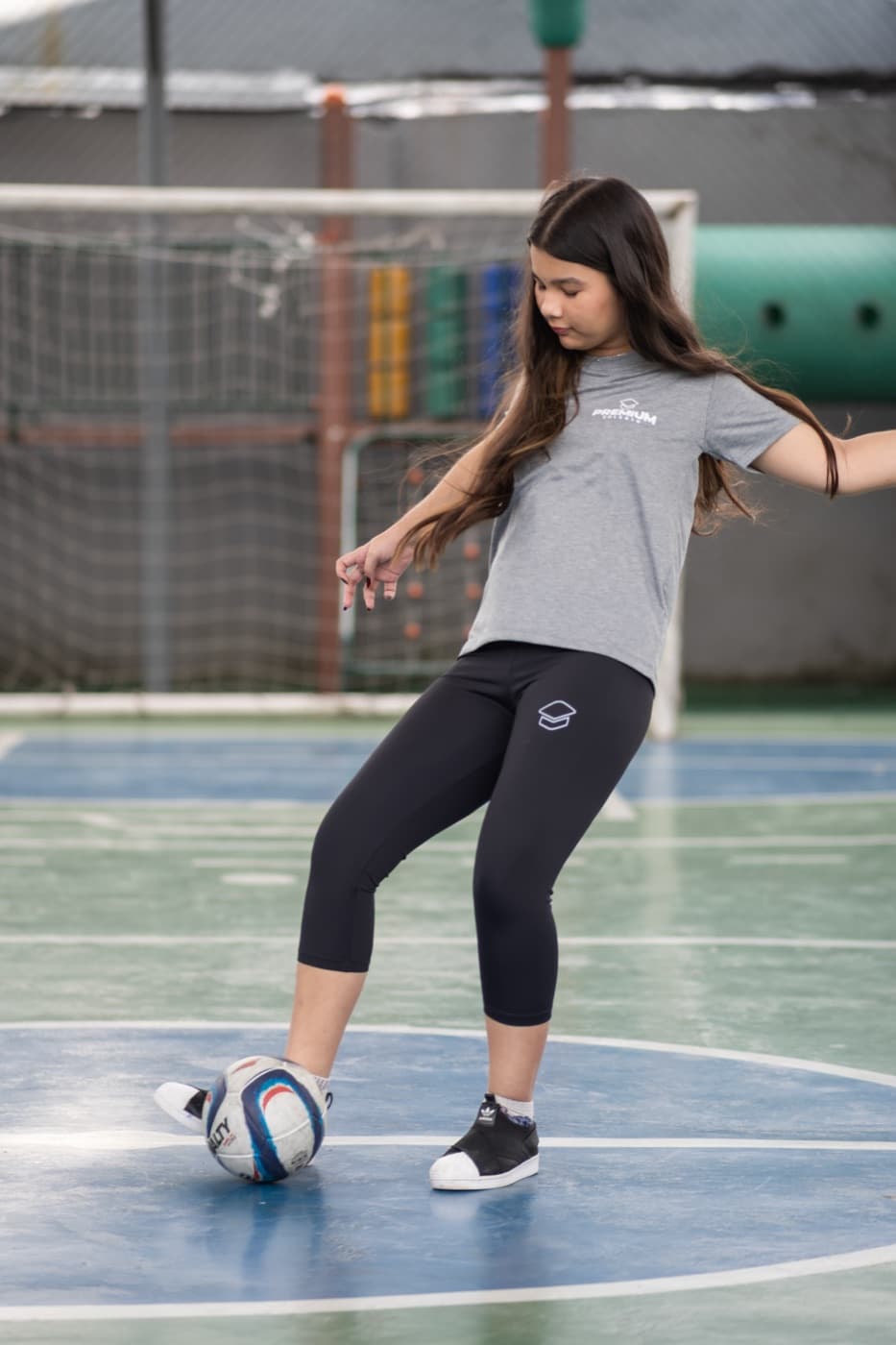 Aluna dominando a bola na quadra poliesportiva do colégio